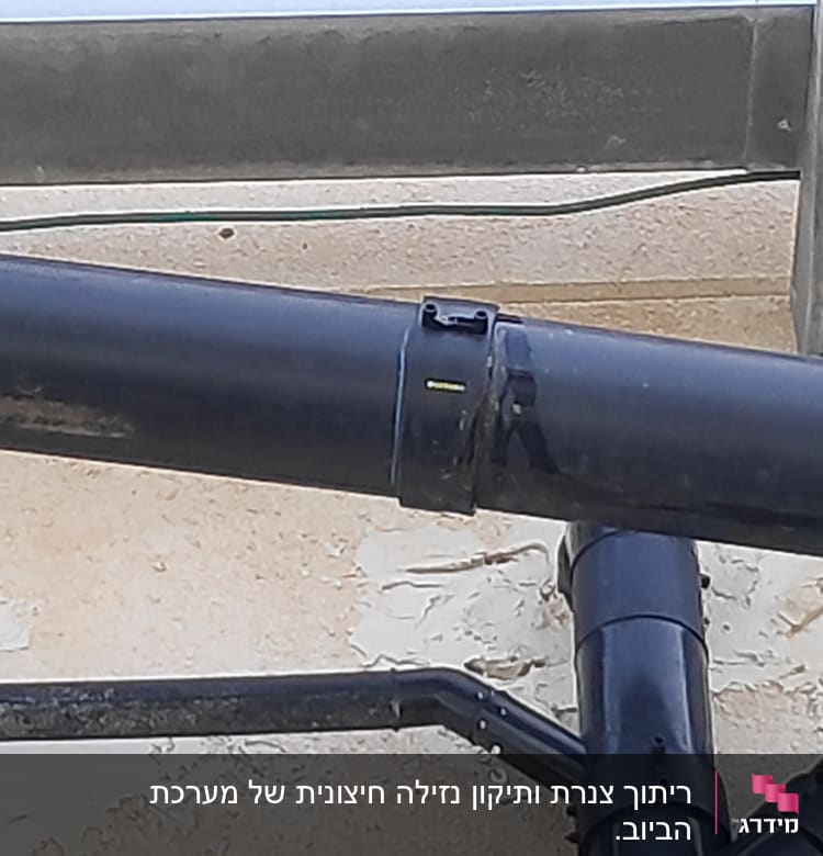 צינורות פלסטיק שחורים מחוברים על קיר חיצוני